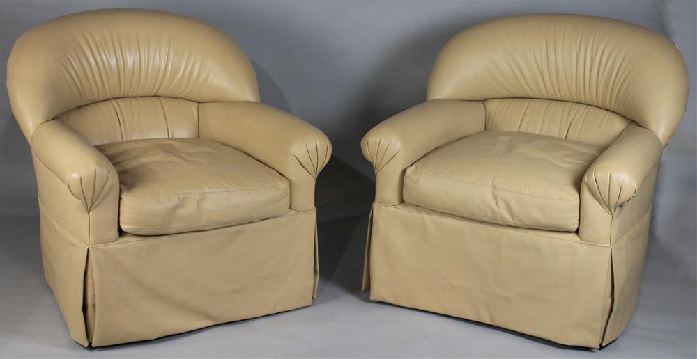 Appraisal: TWO CONTEMPORARY CREAM LEATHER SWIVEL EASY CHAIRS with rolled back