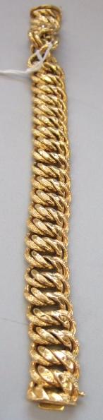 Appraisal: A gold bracelet in a textured and faceted multiple link