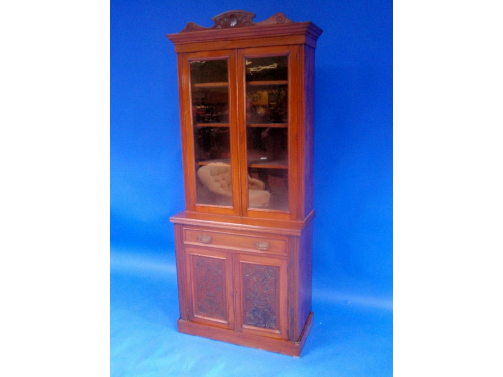 Appraisal: A late Victorian walnut cabinet bookcase with carved cornice two