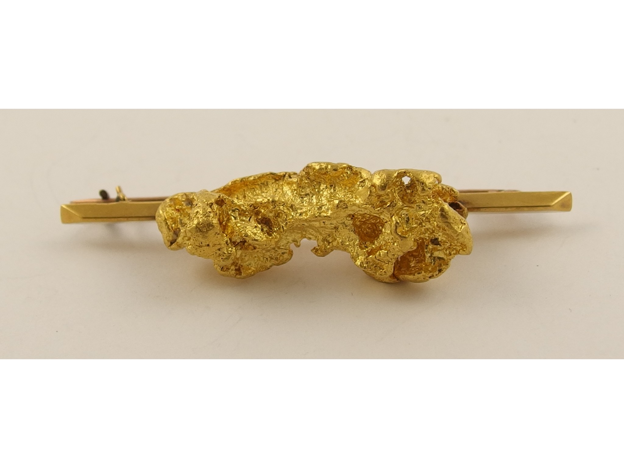 Appraisal: A yellow metal bar broochmounted with a large yellow metal