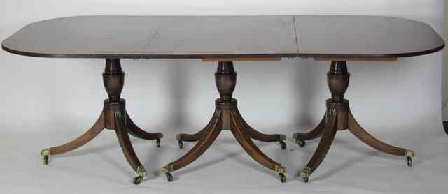 Appraisal: A George III style mahogany three-pillar dining table with two