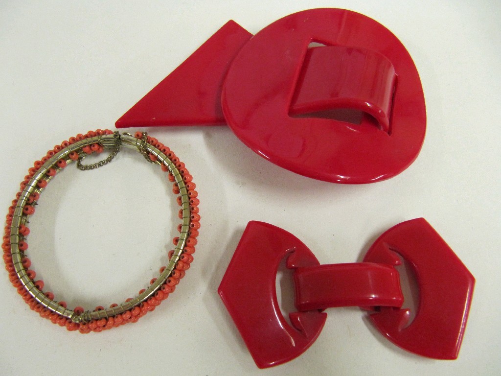 Appraisal: Lot comprising two red plastic buckles and a coral bangle