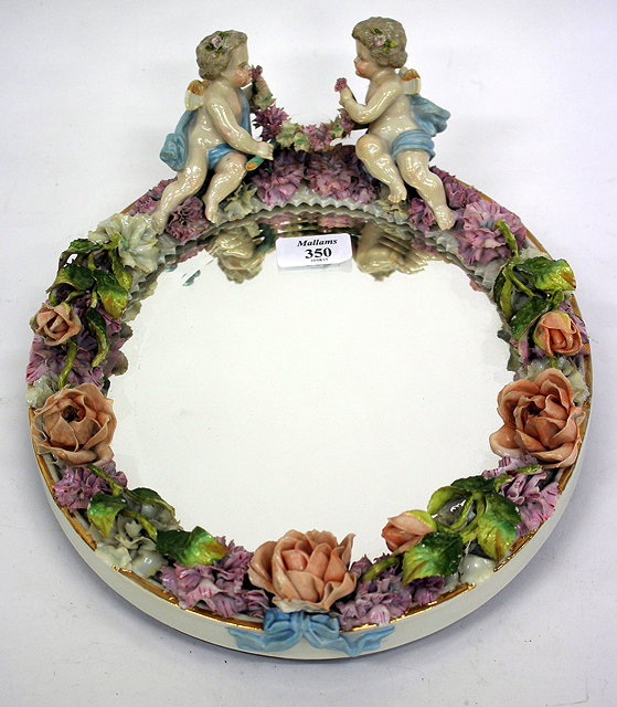 Appraisal: A CONTINENTAL PORCELAIN FRAMED OVAL MIRROR decorated with flower and