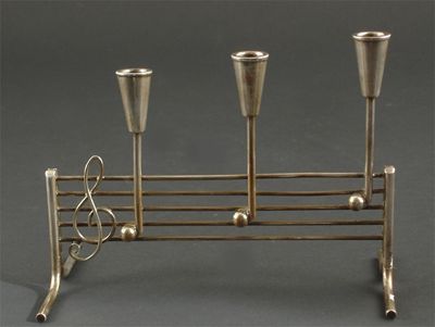 Appraisal: A Danish novelty electroplated candleholder modelled as musical notes stamped