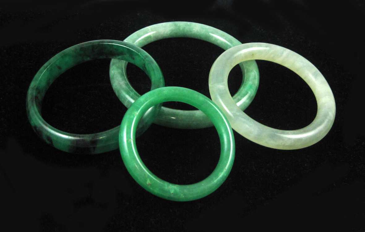 Appraisal: COLLECTION OF FOUR GREEN HARDSTONE BANGLES each round bangle varying