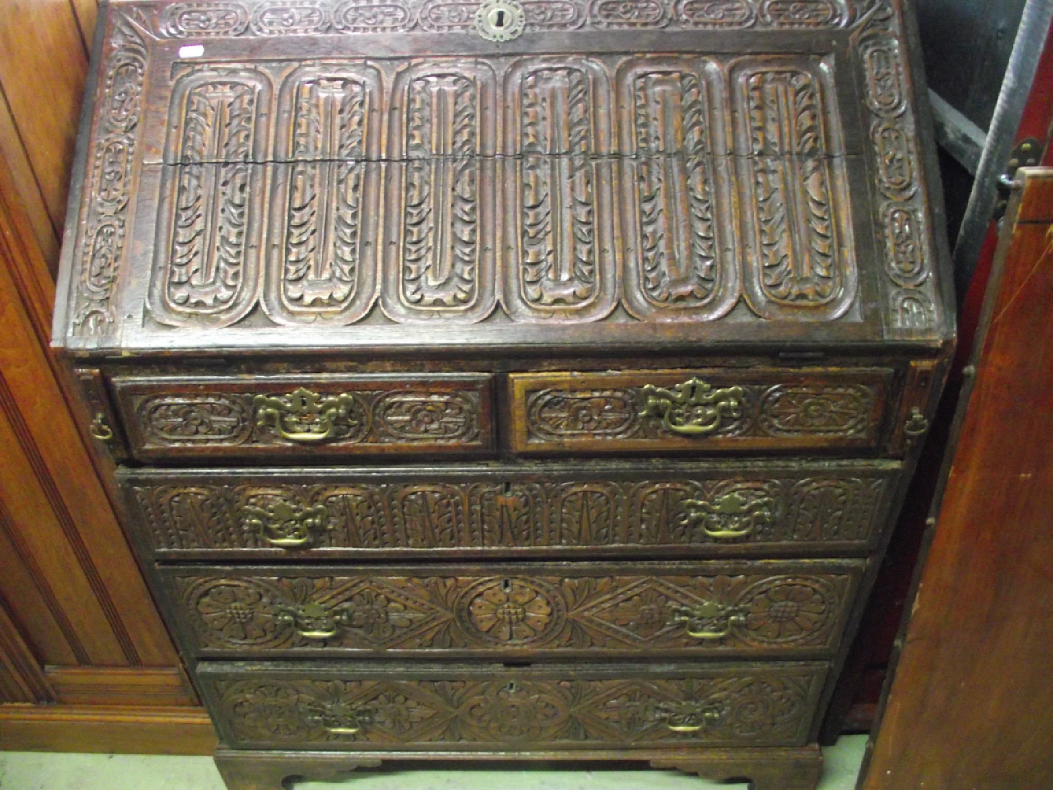 Appraisal: A Georgian oak bureau with later carved detail the fall