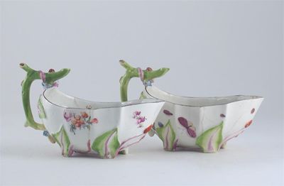 Appraisal: A pair of Chelsea strawberry-moulded sauceboats the interiors with botanical