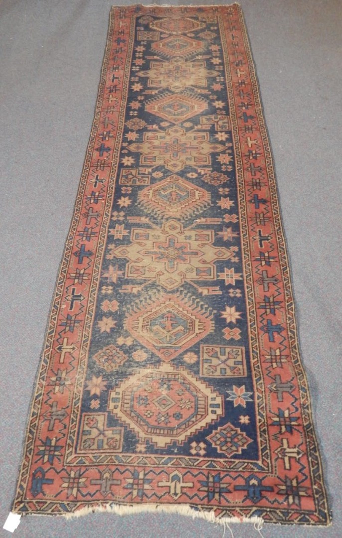 Appraisal: A Persian runner with a design of medallions on a