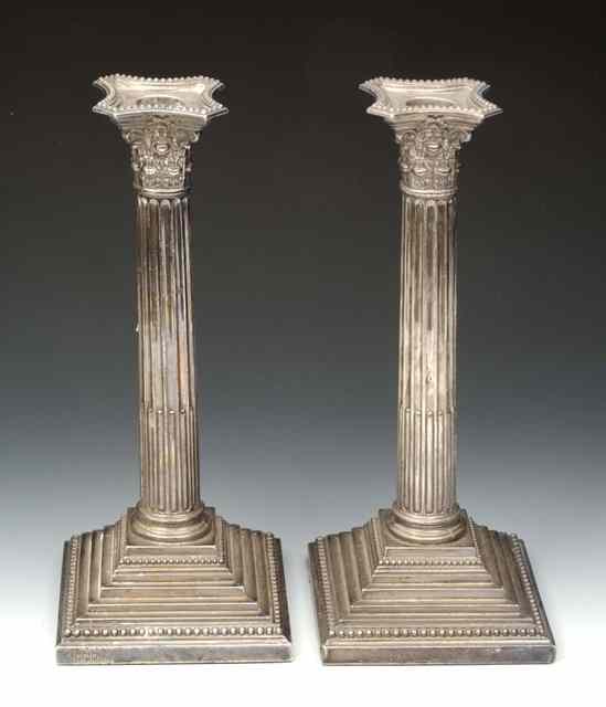 Appraisal: A PAIR OF GEORGIAN STYLE CORINTHIAN COLUMN CANDLESTICKS with shaped