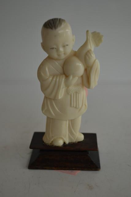 Appraisal: SMALL CHINESE FIGURE OF BOY AND FRUIT