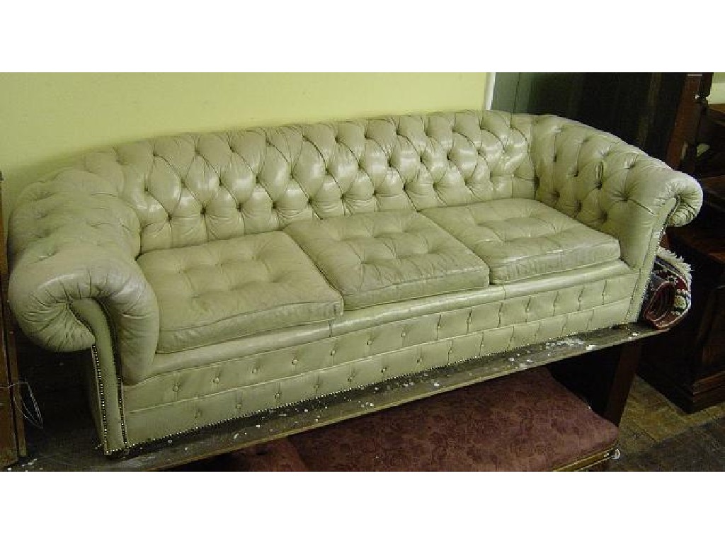 Appraisal: A substantial cream leather upholstered Chesterfield sofa with button back