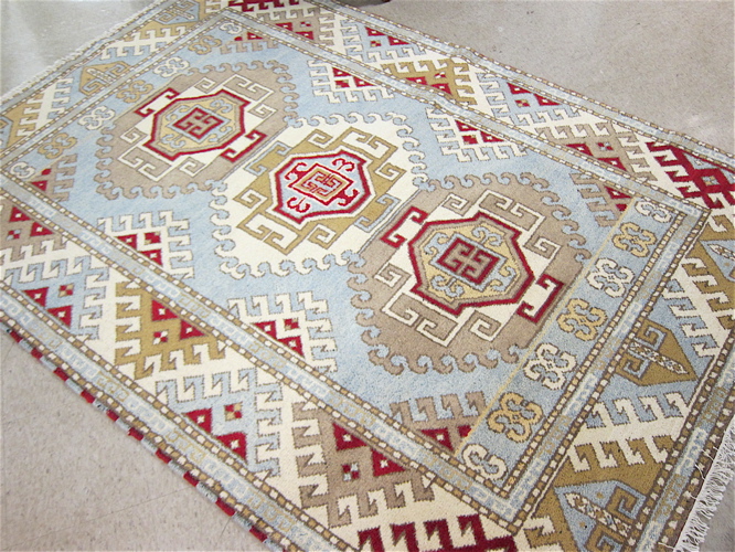 Appraisal: HAND KNOTTED ORIENTAL CARPET Indo-Kazak three geometric medallion design on