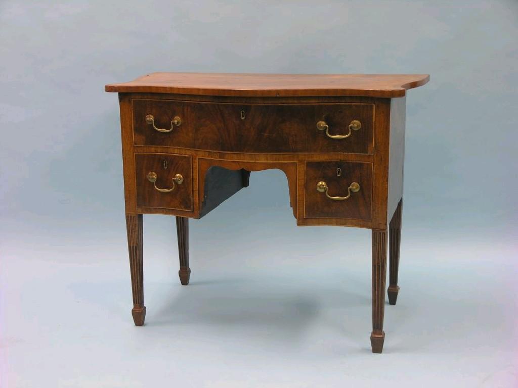 Appraisal: A George III serpentine fronted mahogany kneehole desk cross-banded throughout