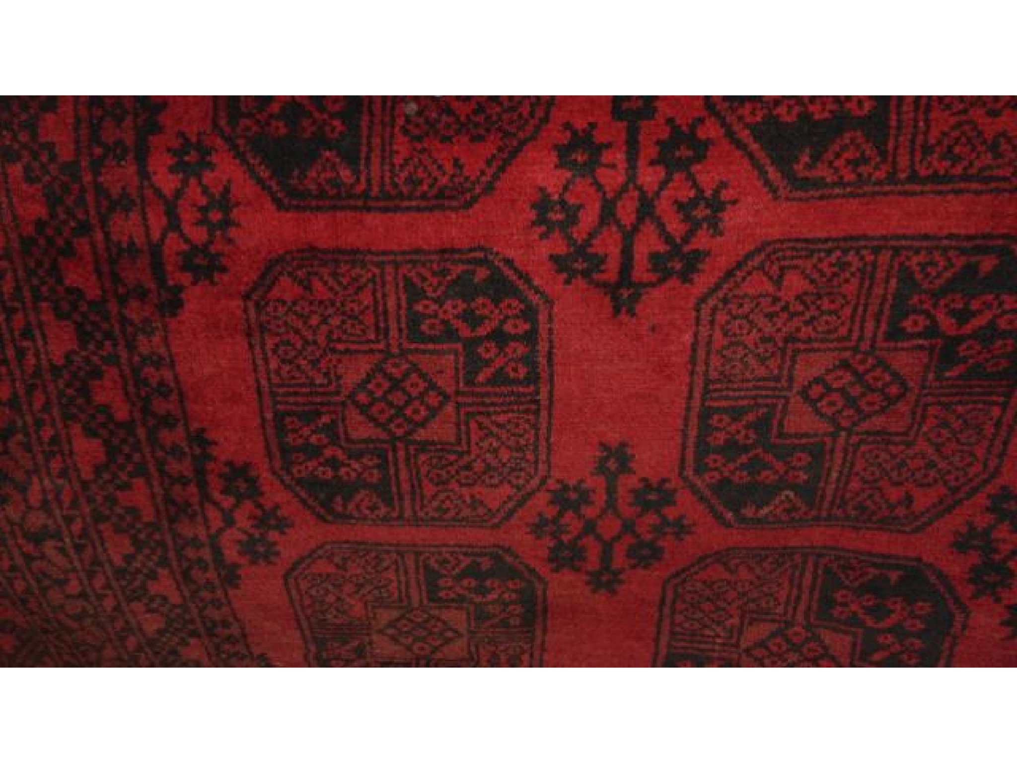 Appraisal: A red ground Afghan style wool carpet in a red