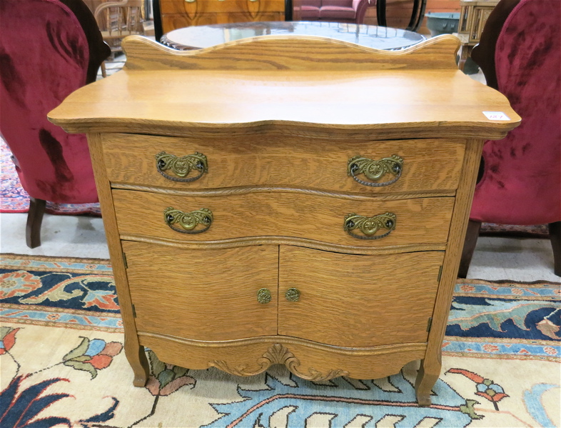 Appraisal: LATE VICTORIAN OAK WASHSTAND American c the serpentine front featuring