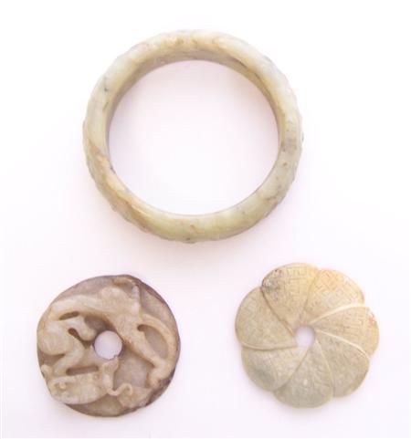 Appraisal: A Chinese pale brown jade disc carved in high relief