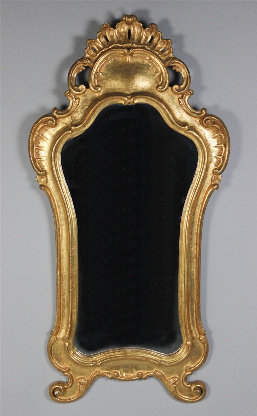 Appraisal: CONTINENTAL ROCOCO STYLE GILTWOOD MIRROR having a shaped mirror plate