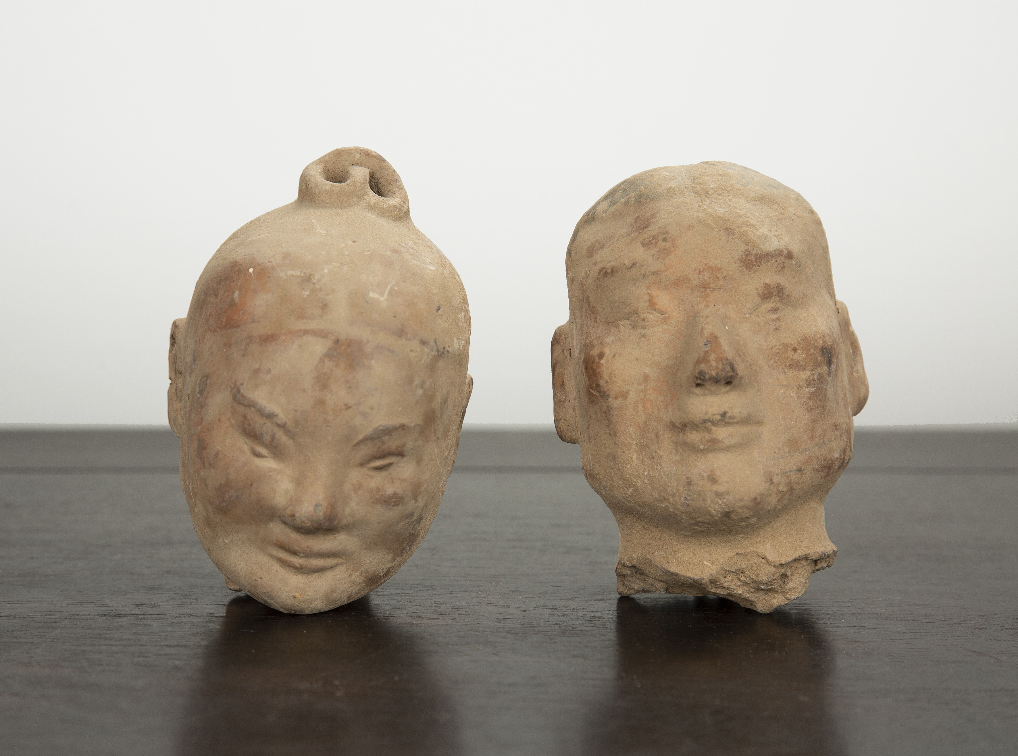 Appraisal: Two clay headsChinese Western Han period probably depicting warriors both