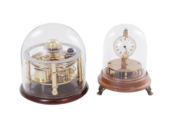 Appraisal: Briggs rotary pendulum and astrological clocks each under glass dome