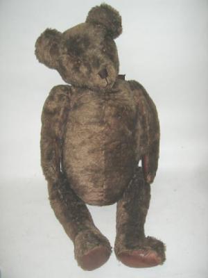 Appraisal: A large English teddy bear covered in brown plush with