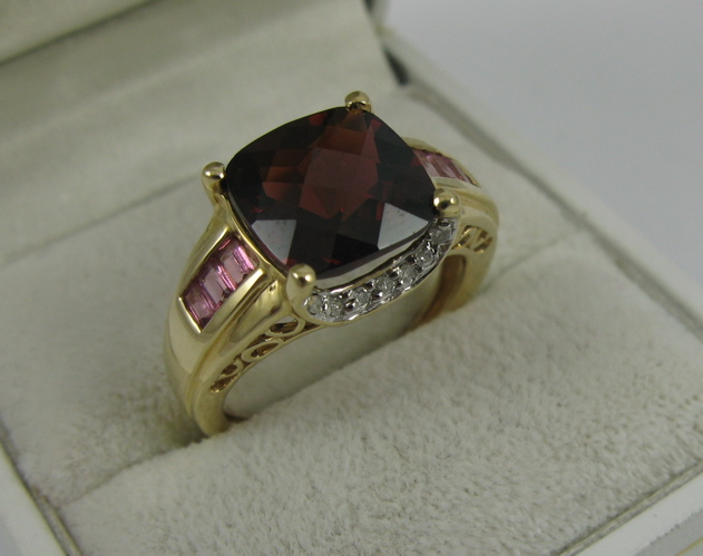 Appraisal: GARNET DIAMOND AND K GOLD RING centering a facet-cut red