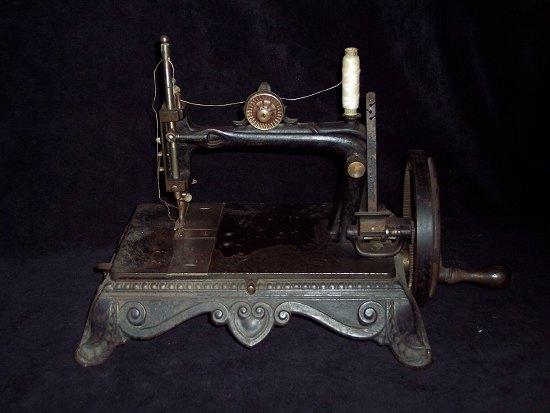 Appraisal: A sewing machine with turned wood handle the rectangular base