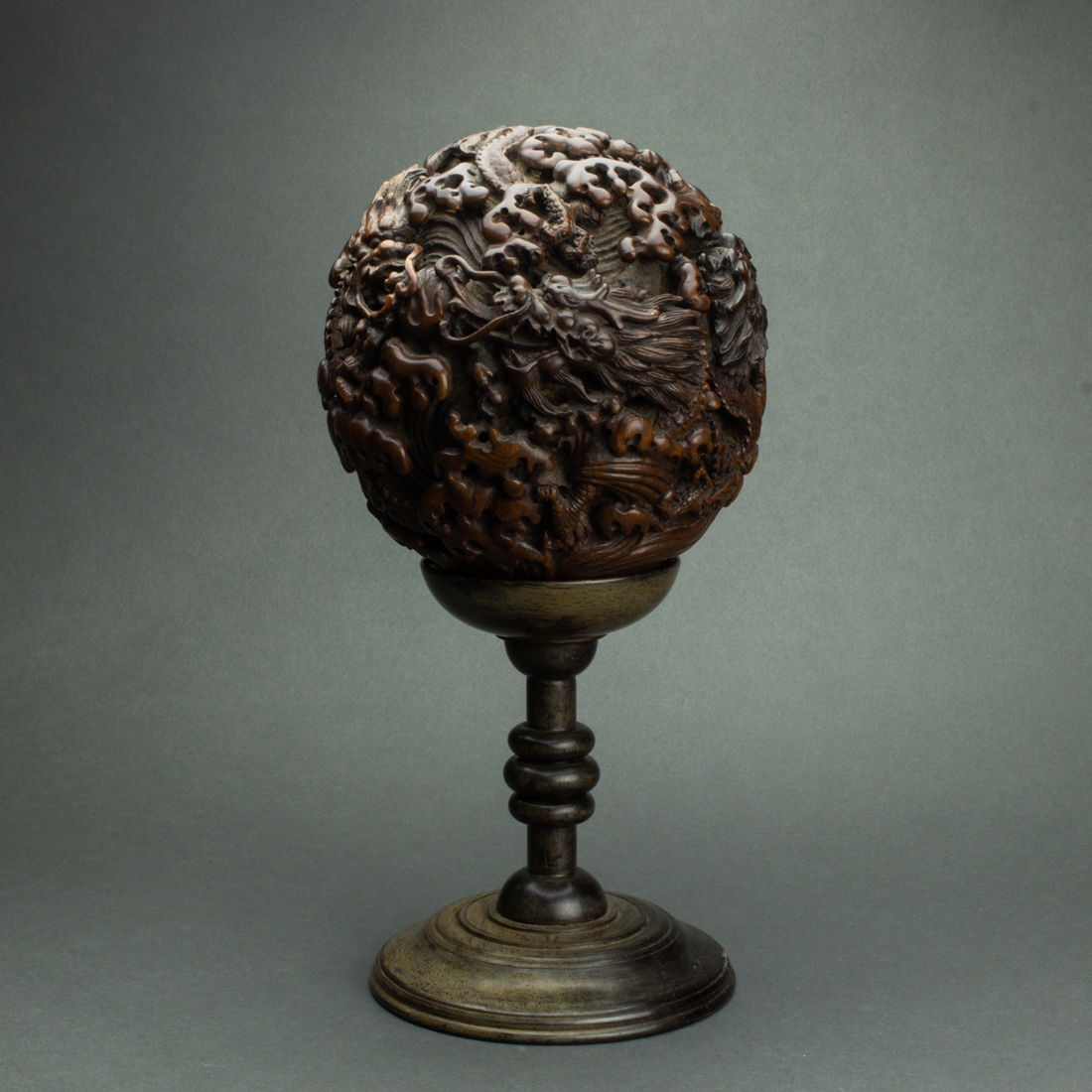 Appraisal: CHINESE HARDWOOD 'DRAGON' SPHERE AND STAND Chinese hardwood 'dragon' sphere