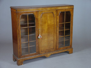 Appraisal: A walnut bookcase th century the carved top above central