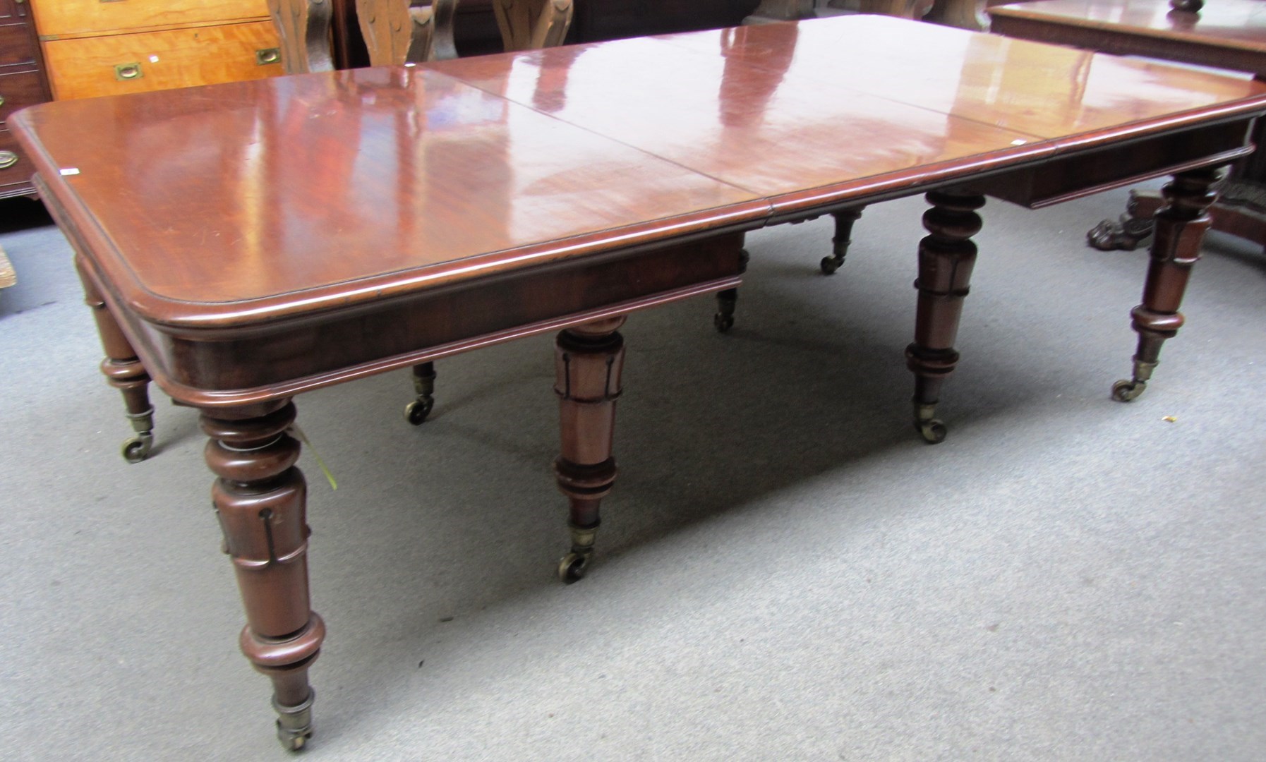 Appraisal: A Victorian mahogany extending dining table on eight lappet carved