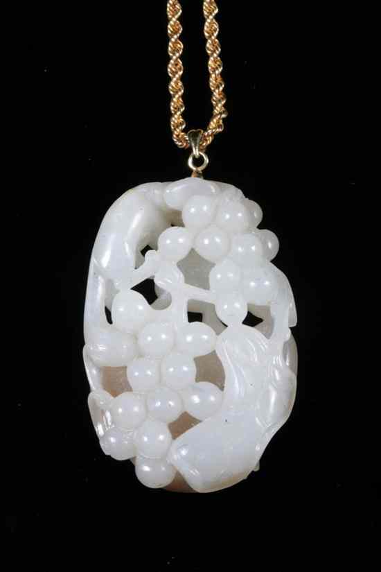 Appraisal: CHINESE CARVED CELADON AND RUSSET COLOR JADE FRUIT-AND-ANIMAL PENDANT Oval