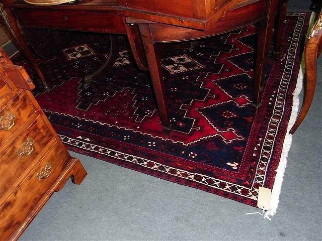 Appraisal: A PAKISTAN RED GROUND RUG with central blue medallion and