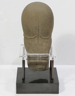 Appraisal: Indigenous style stone sculpture with stylized features resting in an