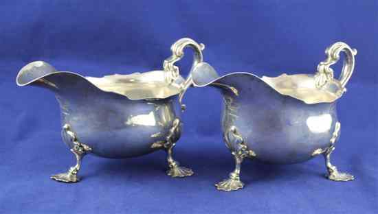 Appraisal: A pair of Edwardian silver sauceboats with scroll handle and