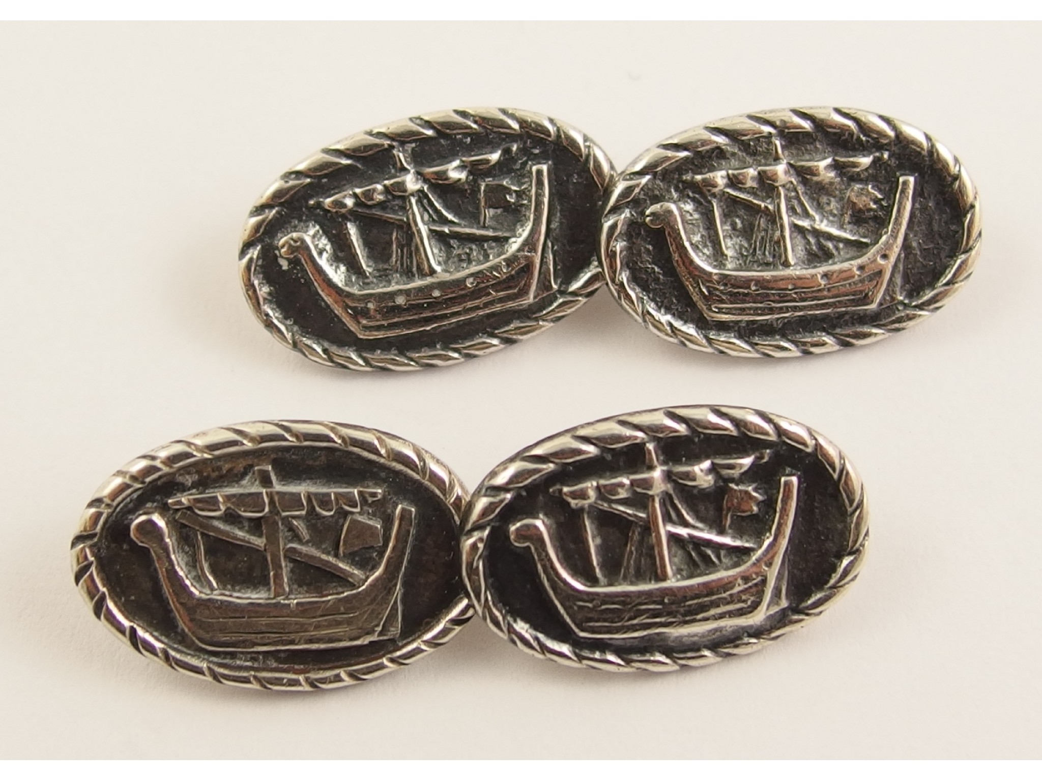 Appraisal: A pair of Alexander Ritchie silver cufflinksdepicting Viking longships within