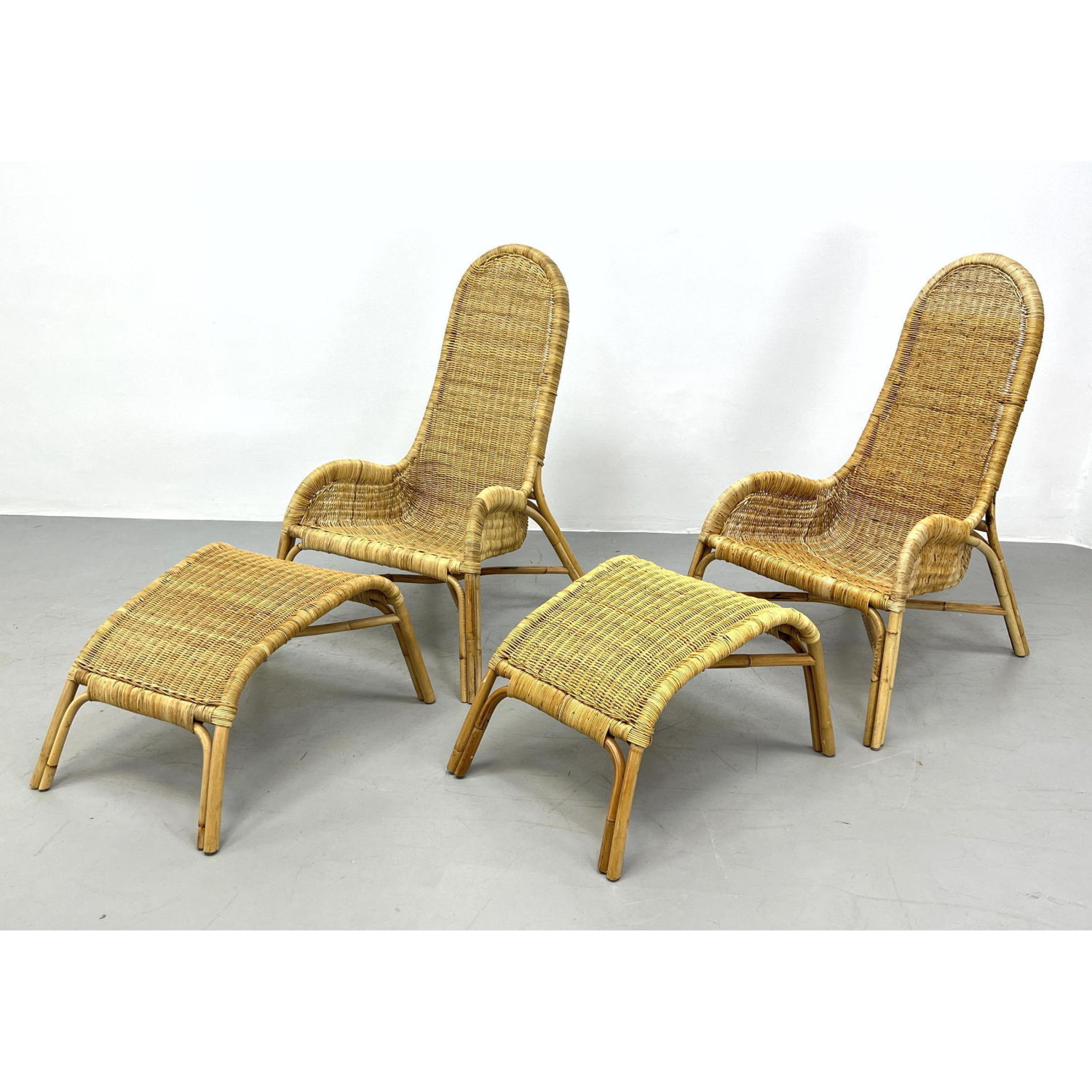 Appraisal: Pair Vintage Woven Rattan Lounge Chairs Ottomans Stylish sloped arm