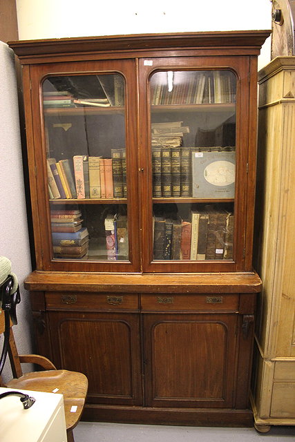 Appraisal: A MAHOGANY LIBRARY BOOKCASE with glazed doors above two frieze