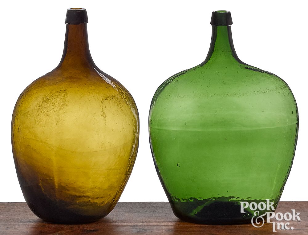 Appraisal: Two emerald and olive green glass demijohn bottles Two emerald