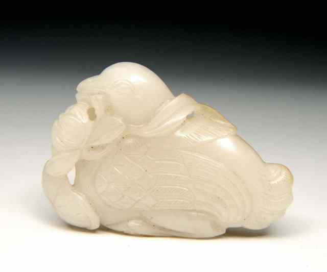 Appraisal: A CHINESE MUTTON FAT JADE PEBBLE carved as a mandarin