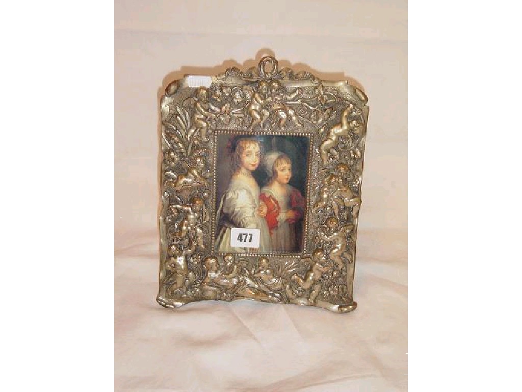 Appraisal: A cast metal frame with relief decoration of cherubs and