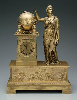 Appraisal: Egyptian Revival bronze clock standing classical figure beside tapered plinth