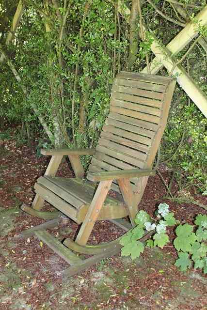 Appraisal: A SET OF SIX TEAK ROCKING GARDEN ARMCHAIRS with shaped