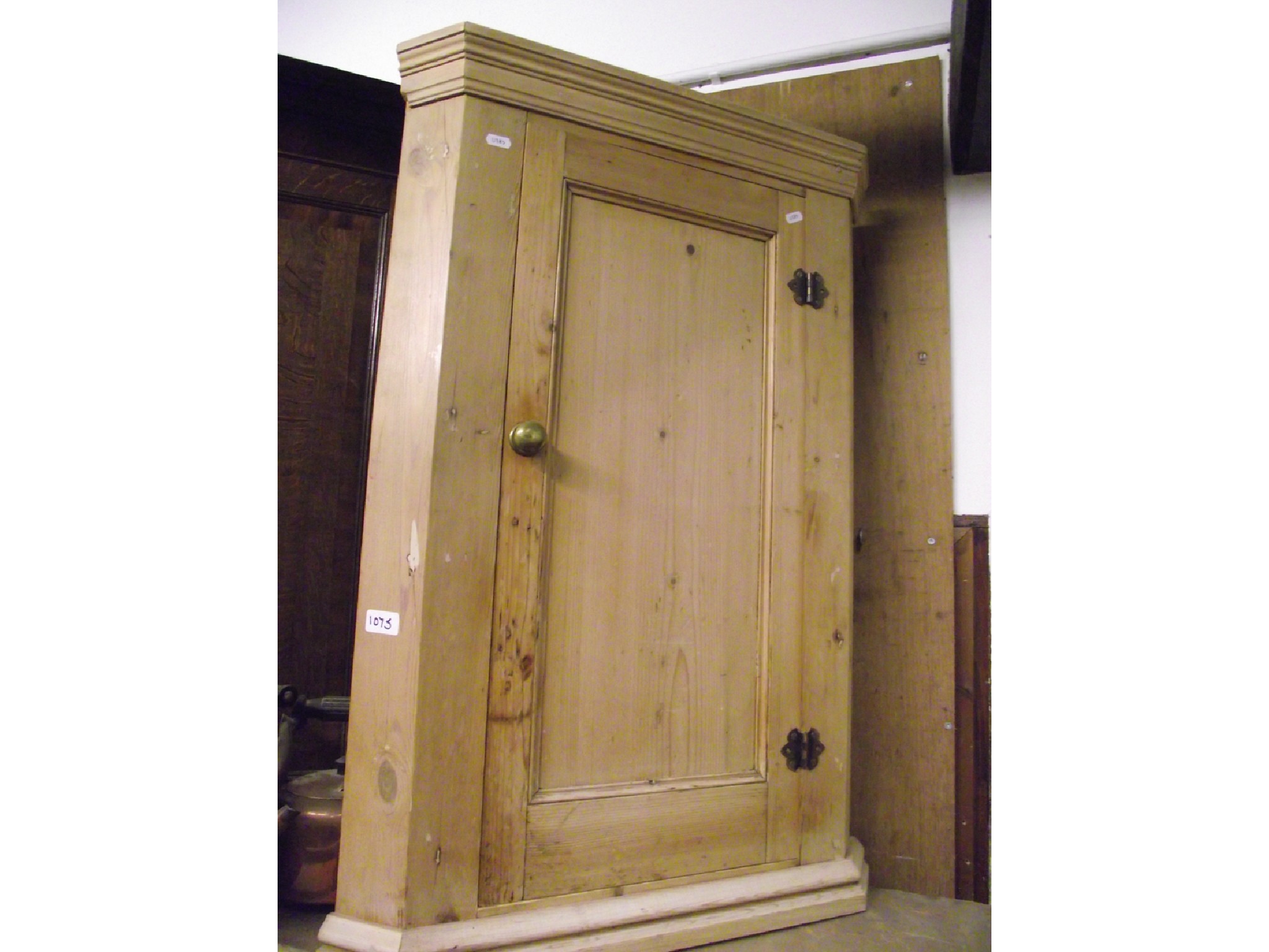 Appraisal: A stripped pine hanging corner cupboard enclosed by a rectangular