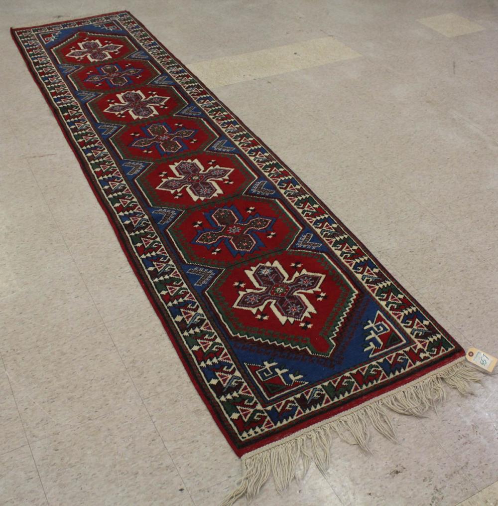 Appraisal: HAND KNOTTED TURKISH RUNNER seven cruciform medallion design on red