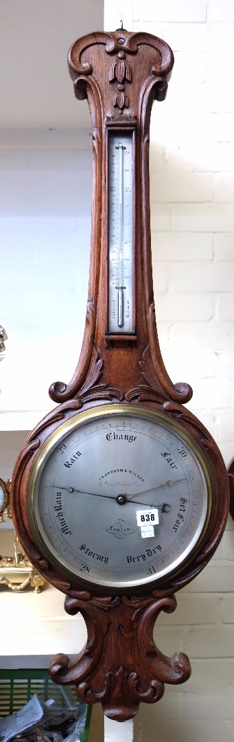 Appraisal: A Victorian oak cased wheel barometer with all over foliate