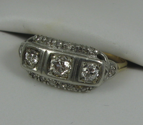 Appraisal: DIAMOND AND FOURTEEN KARAT YELLOW AND WHITE GOLD RING centering