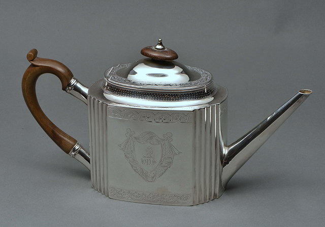 Appraisal: A GEORGE III SILVER TEAPOT with bright cut and fluted