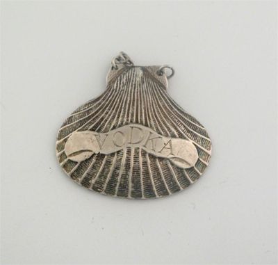 Appraisal: A modern cast scallop shell wine label 'VODKA'