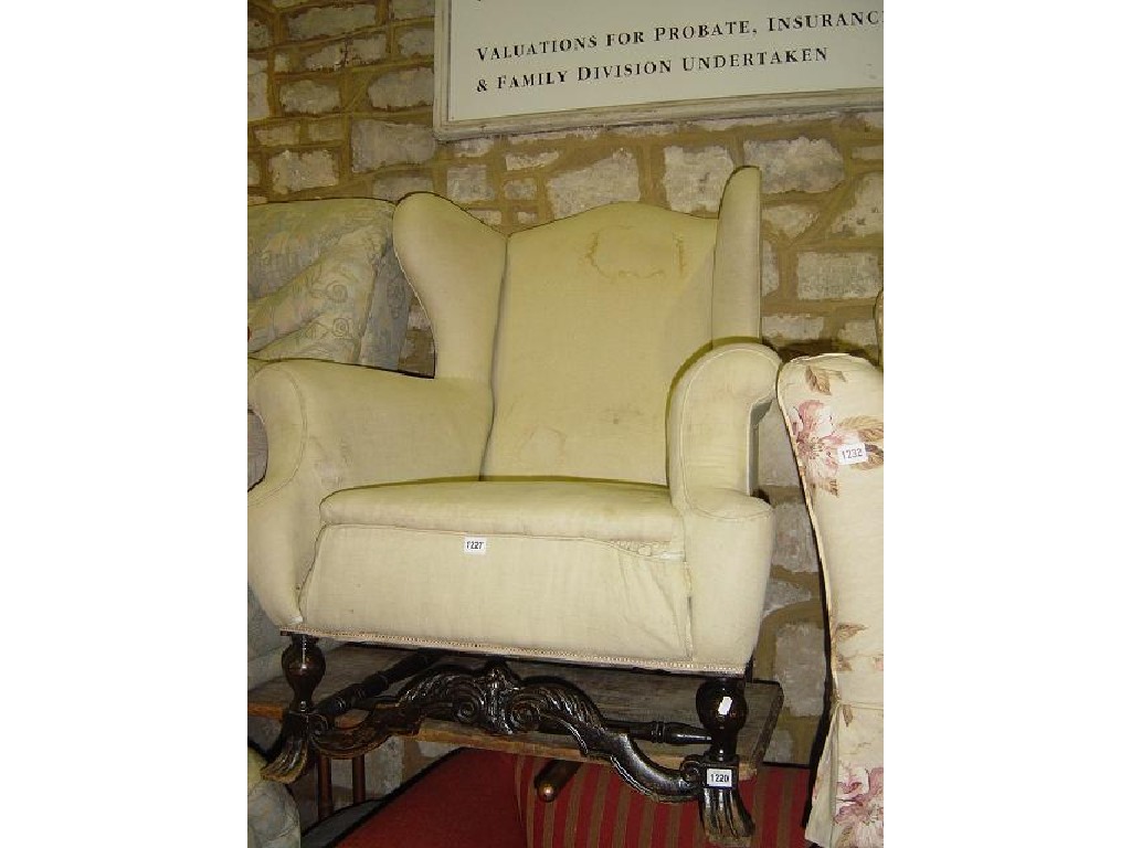 Appraisal: A Carolean style wing armchair raised on turned supports united