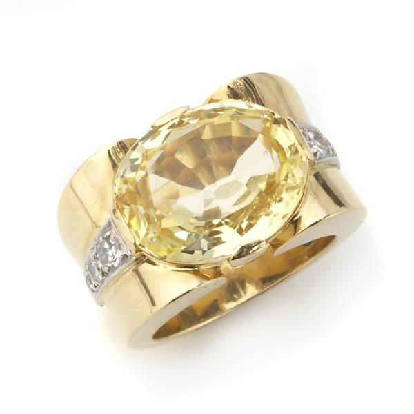 Appraisal: A yellow sapphire and diamond ring centering one oval-shaped sapphire