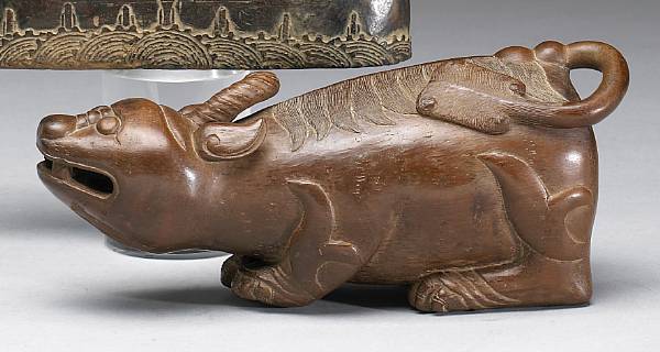 Appraisal: A carved bamboo qilin The recumbent beast carved from a